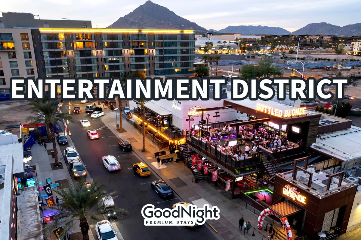 This photo showcases the Bottled Blonde bar, a well-known nightlife destination in Scottsdale's Entertainment District. The scene includes vibrant street activity, cars parked along the street, city buildings, and mountains in the background, capturing the lively atmosphere and urban energy of Old Town at night.