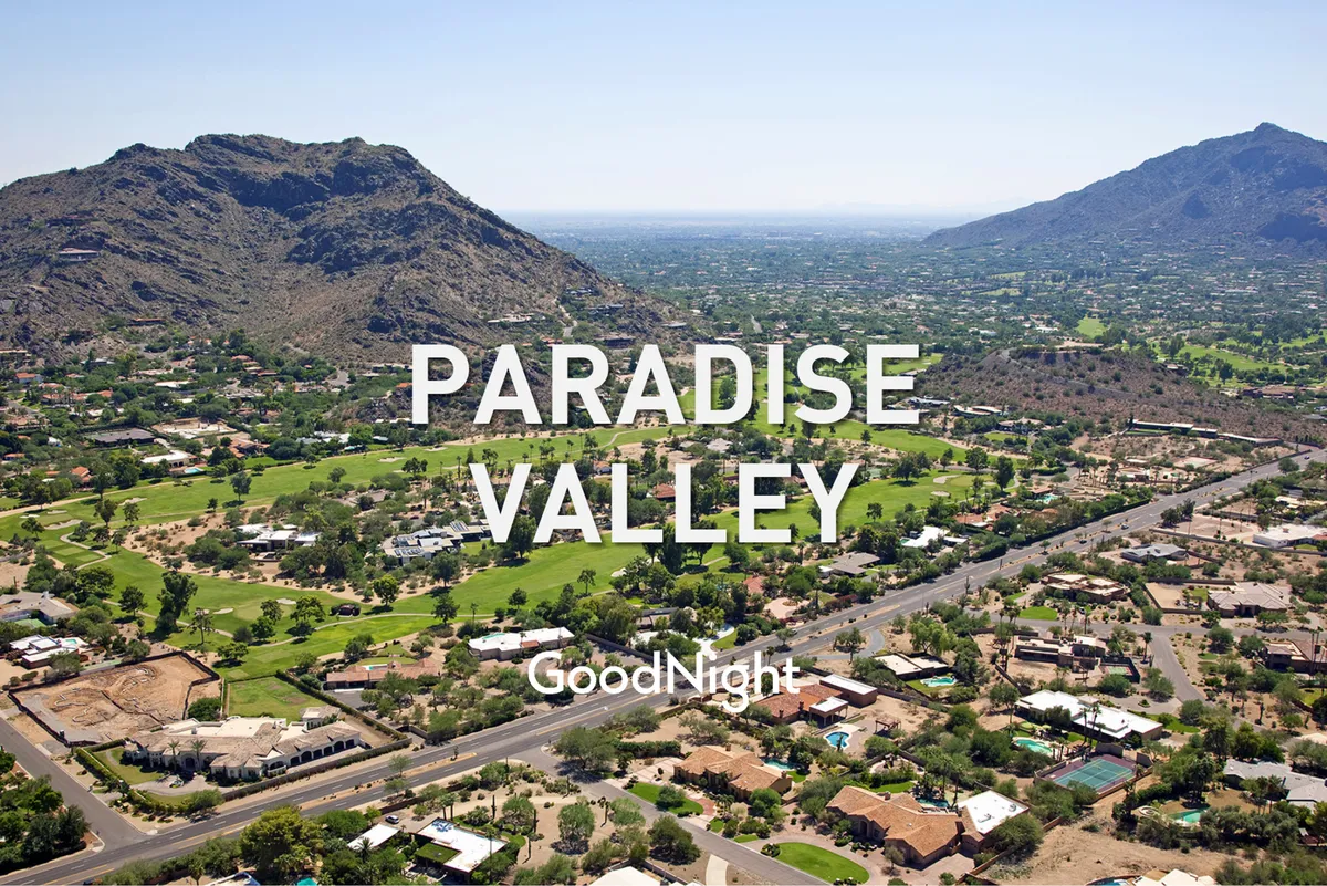 A panoramic view capturing lush green spaces, residential neighborhoods, and rugged mountains beneath an expansive desert sky. The landscape hints at both relaxation and adventure, suggesting endless possibilities for outdoor activities.
