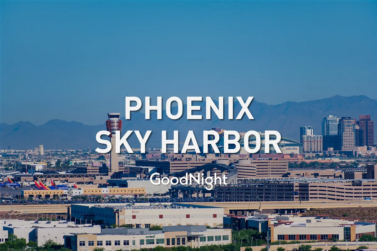 A panoramic view of Phoenix Sky Harbor Airport, with airplanes on the tarmac and the downtown skyline and mountains in the background. The scene buzzes with energy, highlighting the city’s connectivity and accessibility.